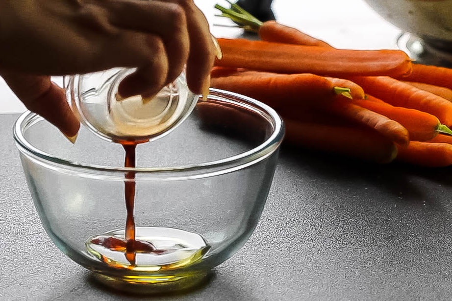 balsamic vinegar being added to olive oil in a glass bowl