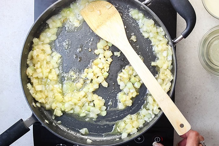 A pan with onions cooking in olive oil and butter