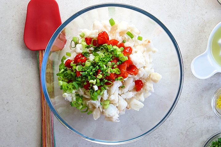 Chopped peppers, chives and green onions in the bowl with the crab