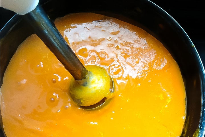 A hand blender pureeing the soup