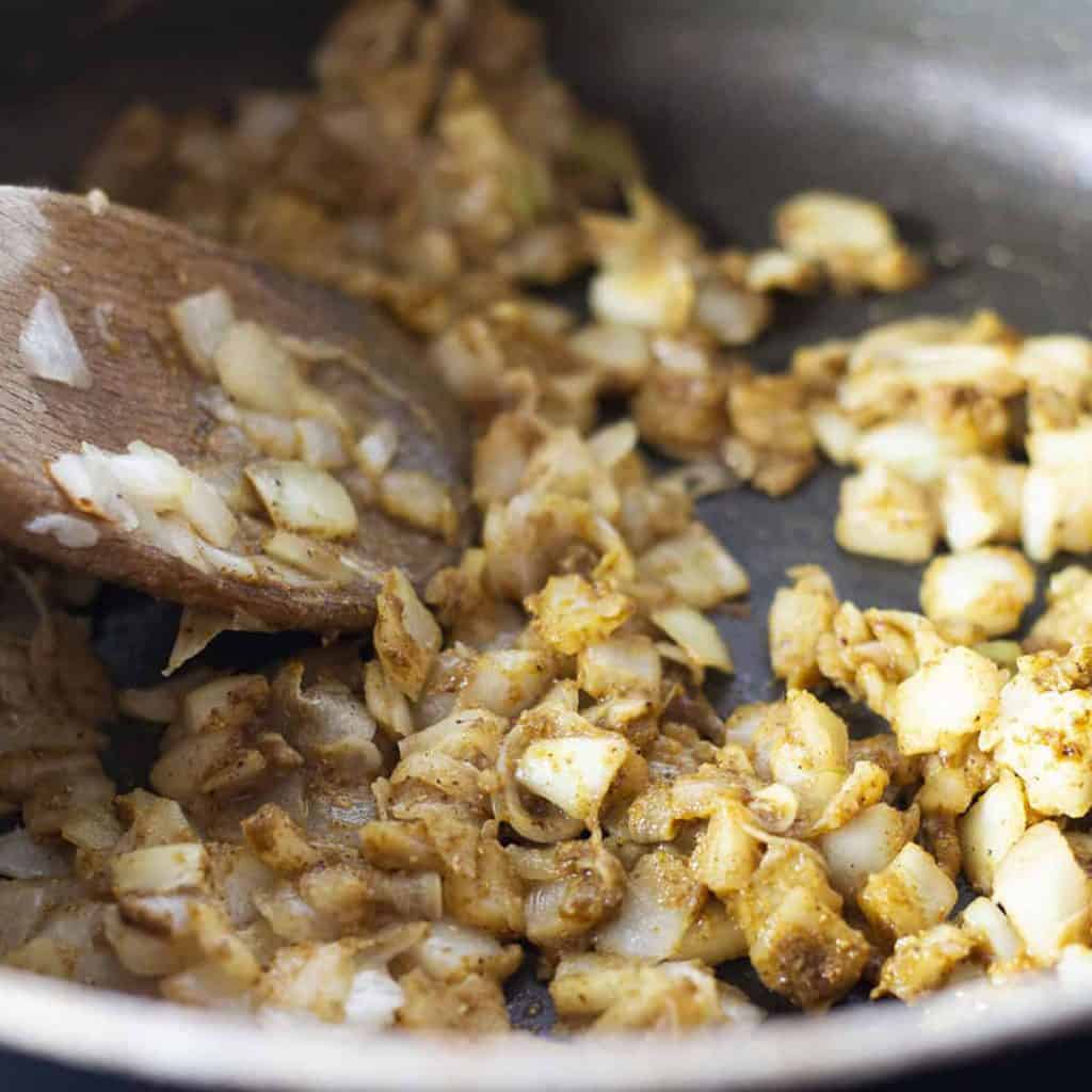 onions and corriander cooking in a pot