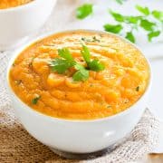 a close up image of a white bowl with carror soup