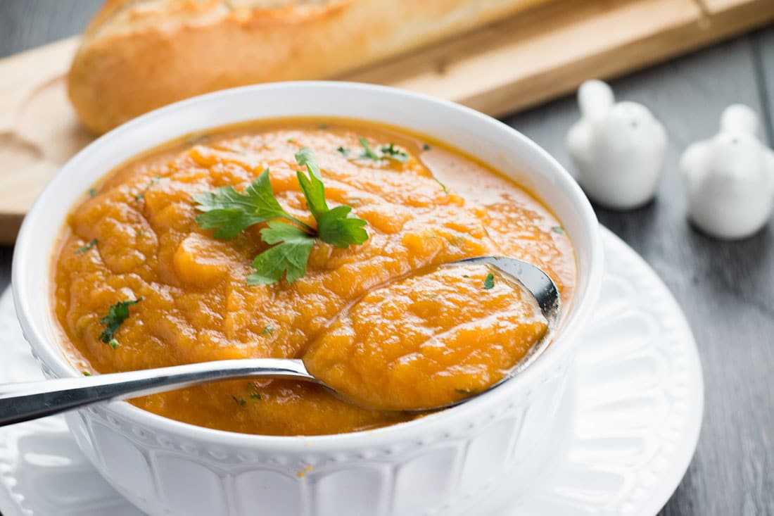 Quick & Easy Carrot and Coriander Soup in a bowl with a spoon.