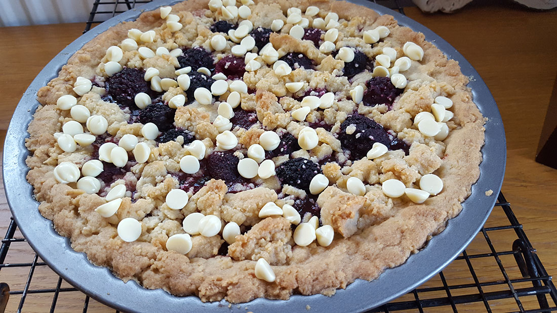 Raspberry and White Chocolate Shortbread Tart sprinkled with white chocolate chips on top