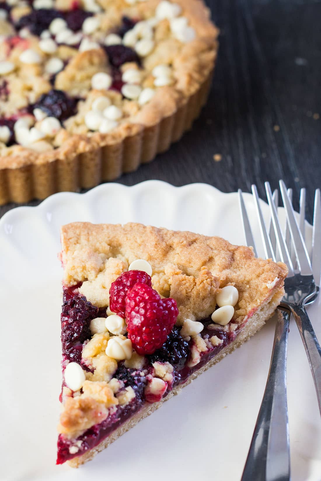 Raspberry and White Chocolate Shortbread Tart slice on a plate with two forks