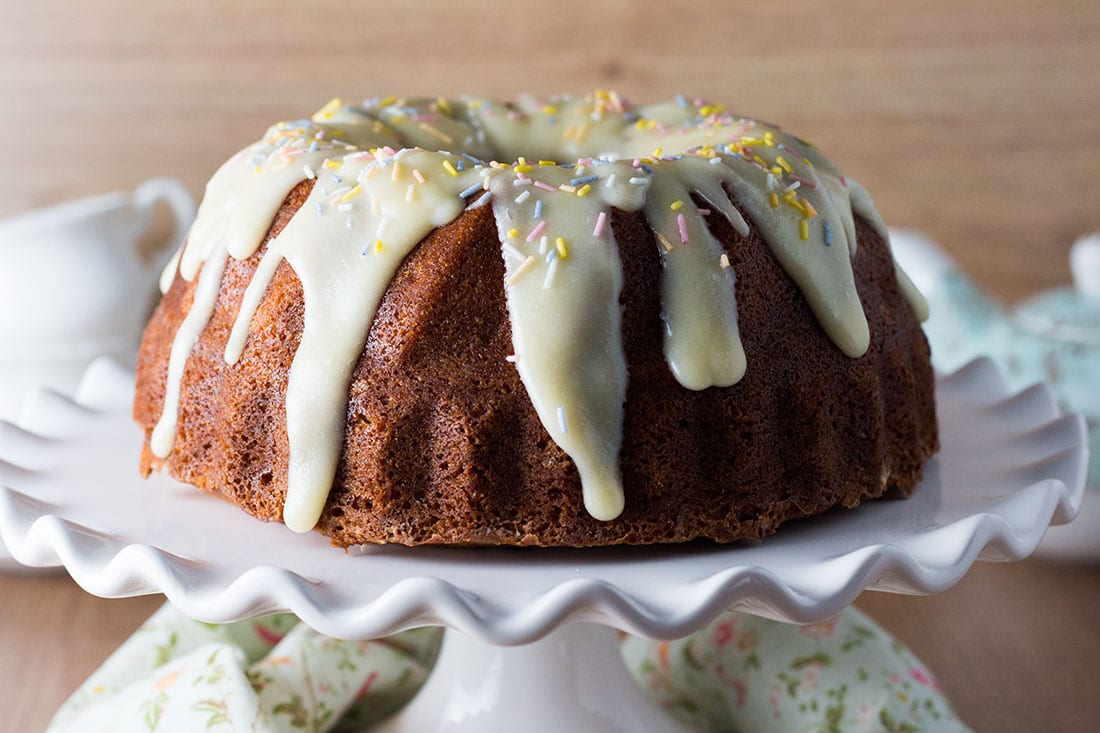  A banana bundt cake on a serving plate drizzled with icing