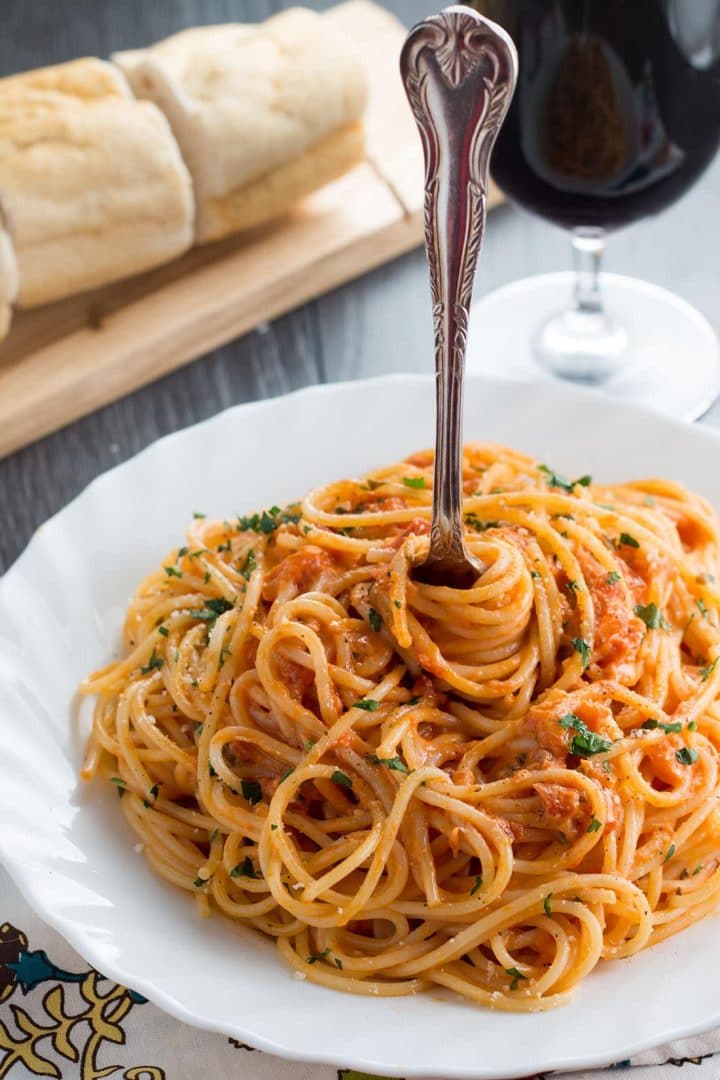 Spaghetti with Skinny Tomato Cream Sauce on a plate with a fork twirling the pasta