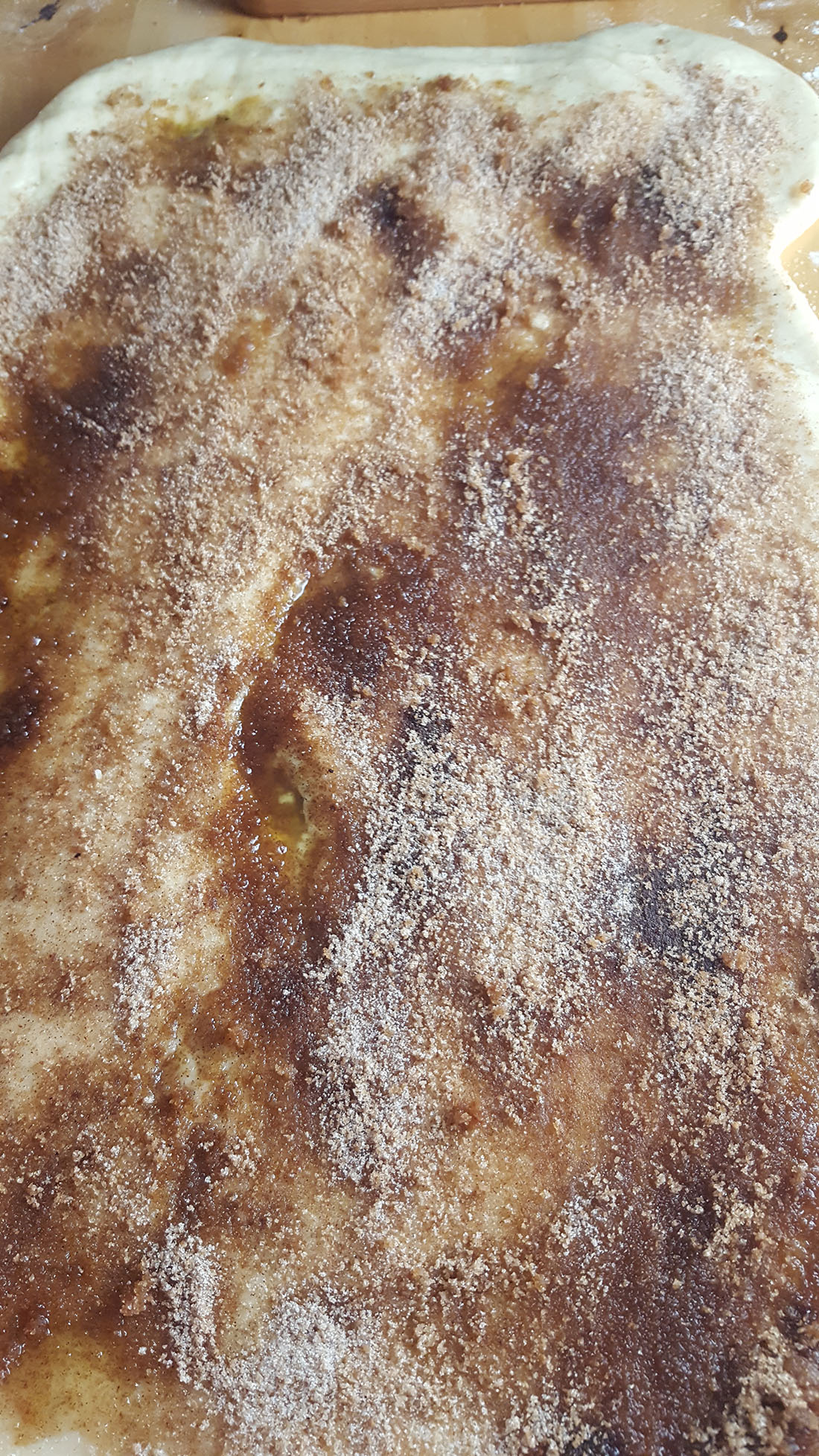 Rolled out dough with cinnamon and sugar spread over the butter mixture