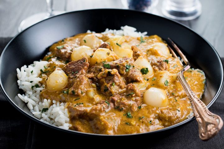 Beef Massaman Thai Curry in a black bowl with rice and a fork