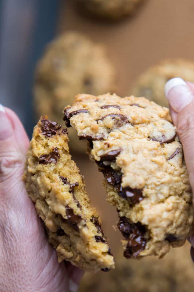 a cookie being broken in two to show the chocolate chips inside