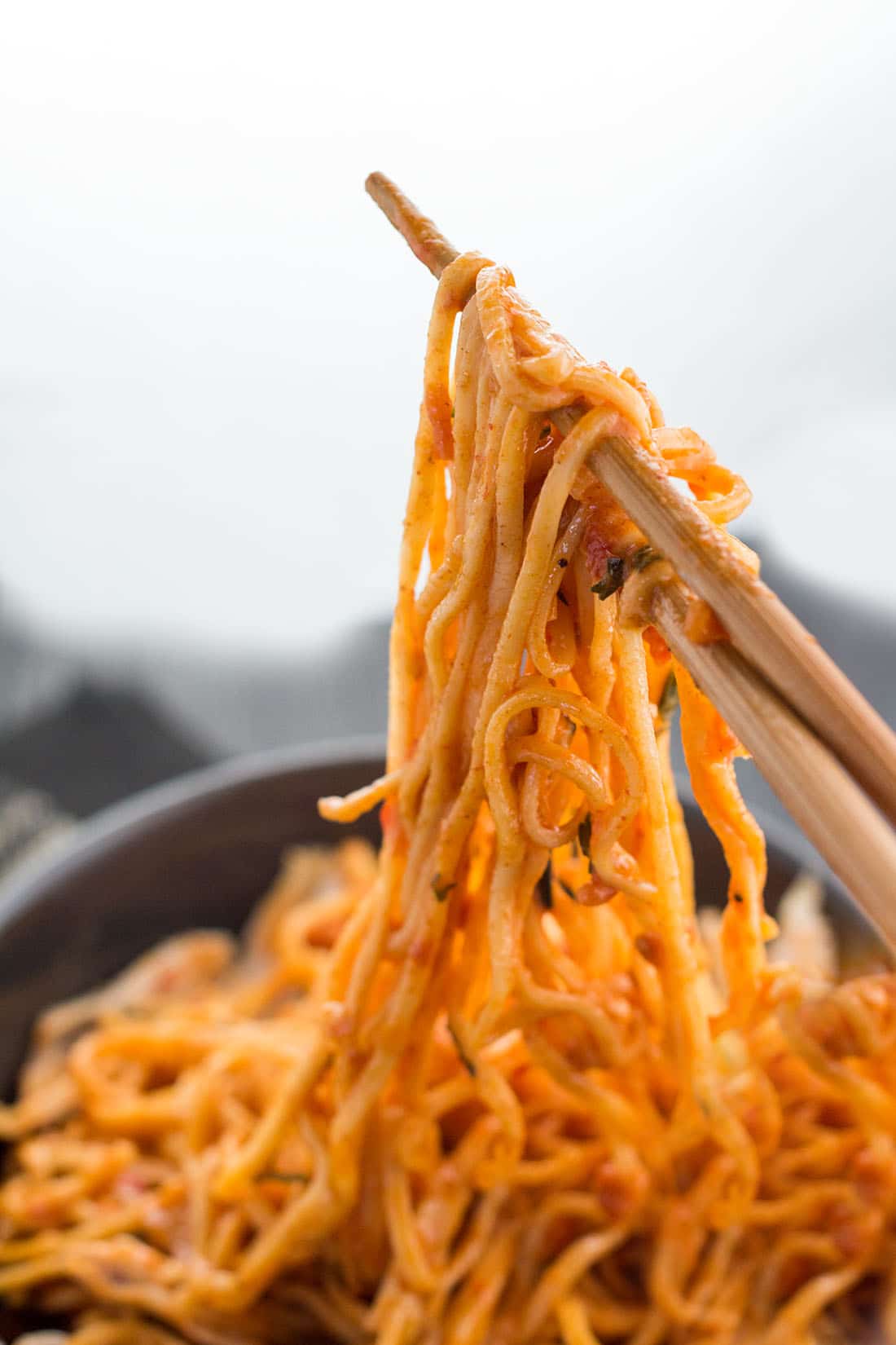 Thai Curry Noodles hanging from chop sticks