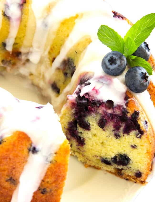 a Lemon Blueberry Bundt Cake with a slice cut out exposing the blueberry filled cake