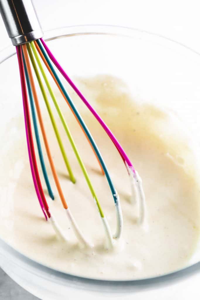 salad dressing being beaten with a whisk