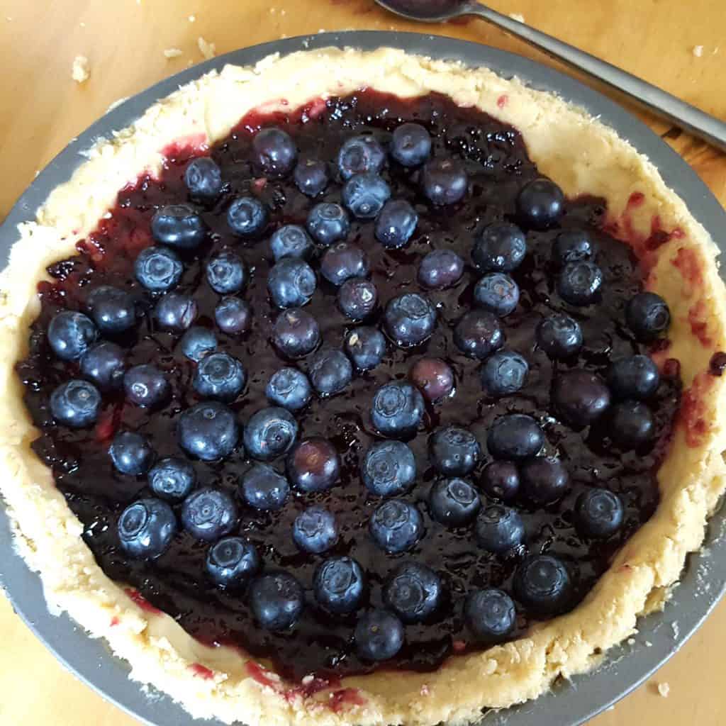 jam and blueberries in a pie shell