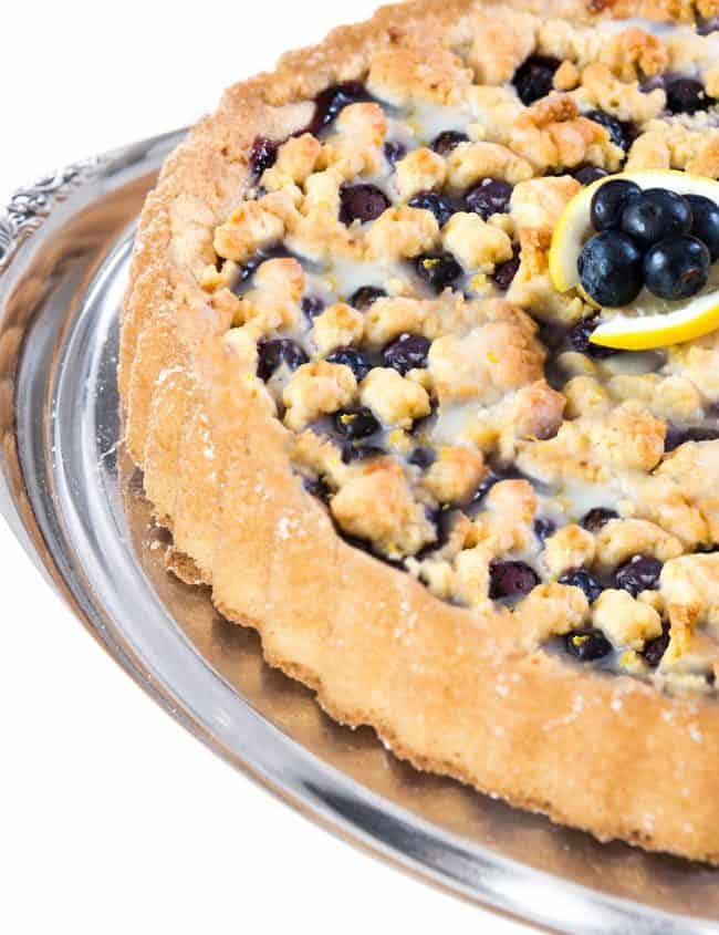 a close up of a blueberry tart with fresh blueberries on top