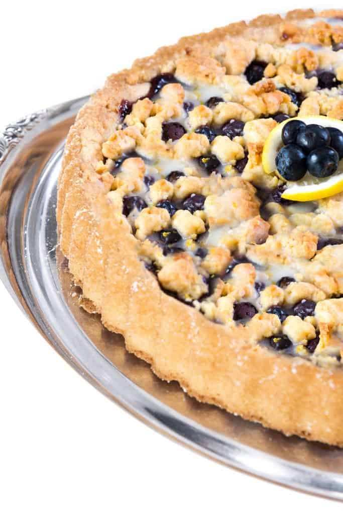 a close up of a blueberry tart with fresh blueberries on top
