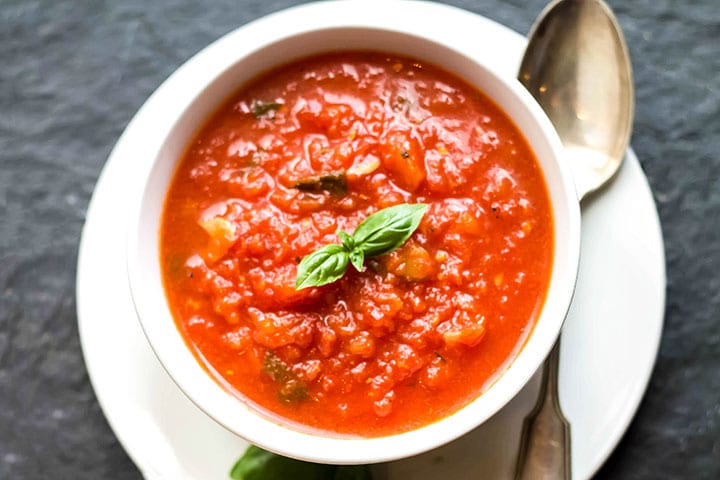 A bowl of Quick & Easy Marinara Sauce topped with fresh basil