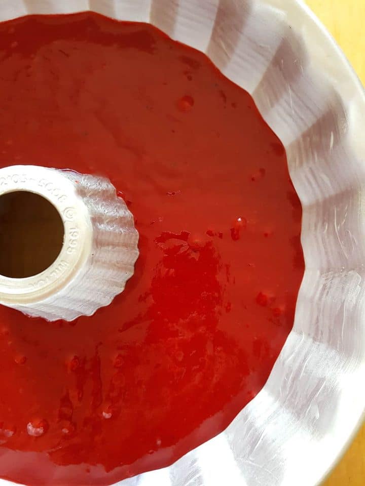 Red Velvet cake batter in a silver Bundt pan