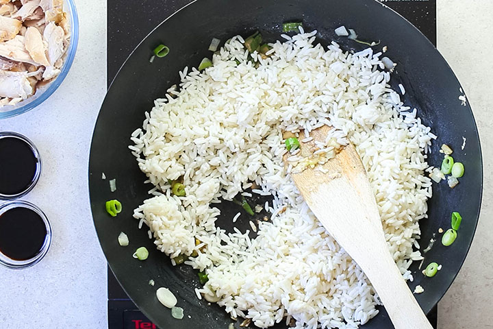 The rice added to the wok with the aromatics