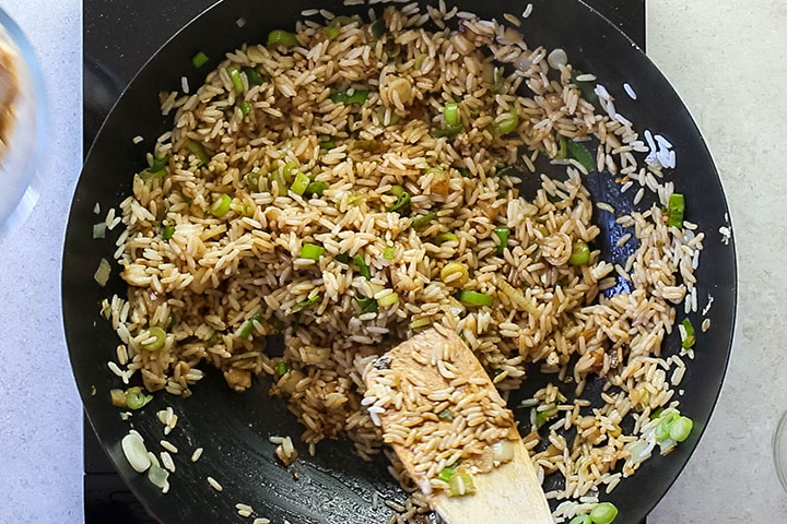 The soy sauce added to the rice mixture in the wok