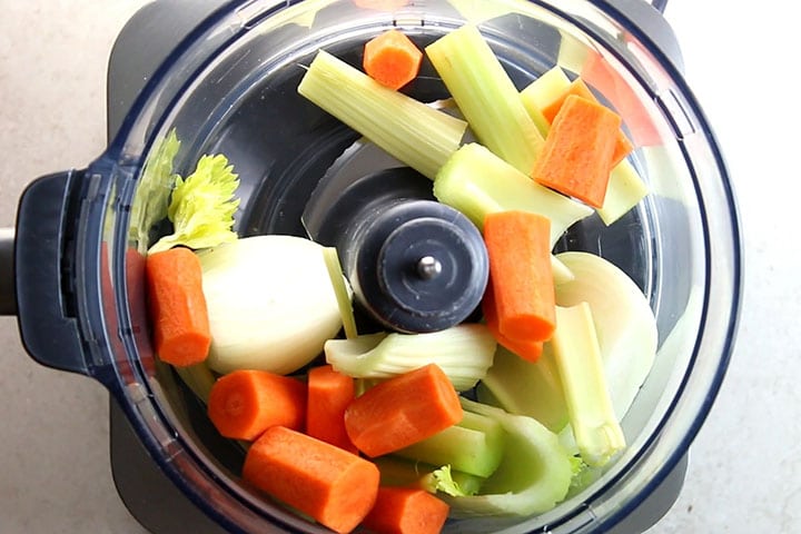 onion carrot and celery in a food processor ready to chop