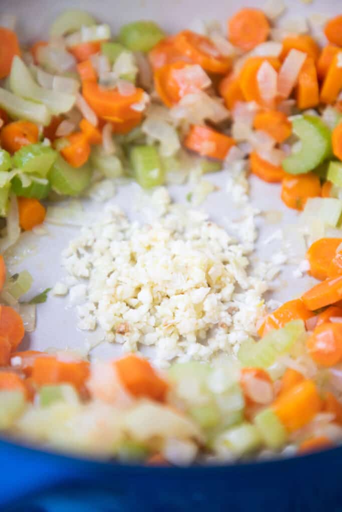 chopped garlic in a well of diced vegetables