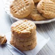 A stack of Classic Peanut Butter Cookies with a spoonful of peanut butter next to it