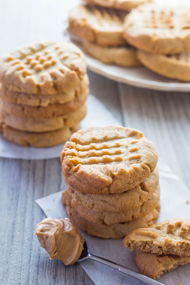 Two stacks of Classic Peanut Butter Cookies with a spoonful of peanut butter next to it