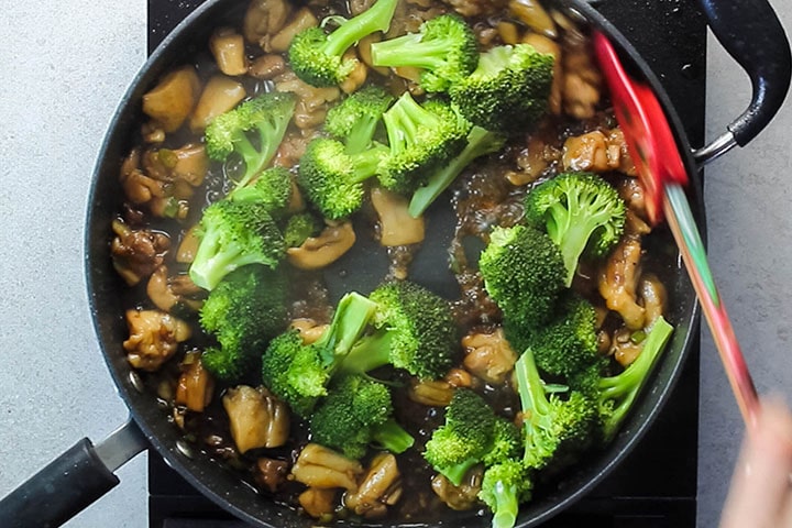 The steamed broccoli added to the pan with the chicken mixture