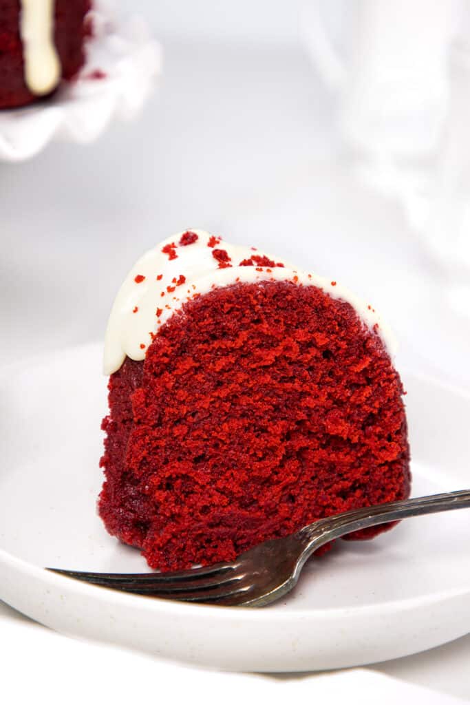 a slice of Red Velvet Bundt Cake on a plate with a fork