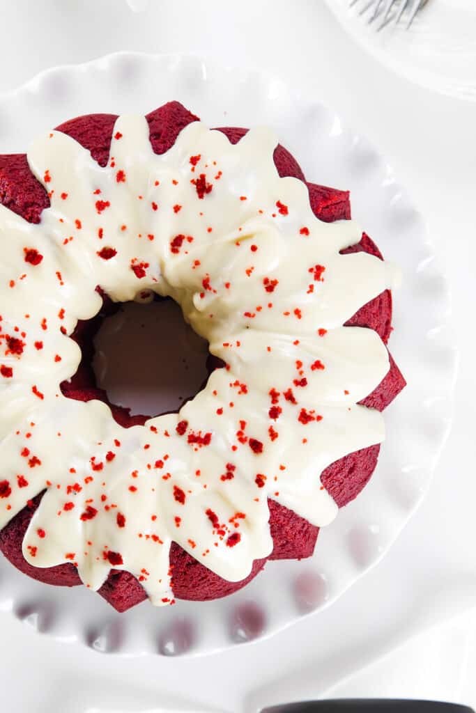 the iced Red Velvet Bundt Cake decorated with cake crumbs