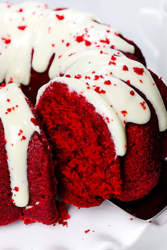 a slice of Red Velvet Bundt Cake being removed with a cake server