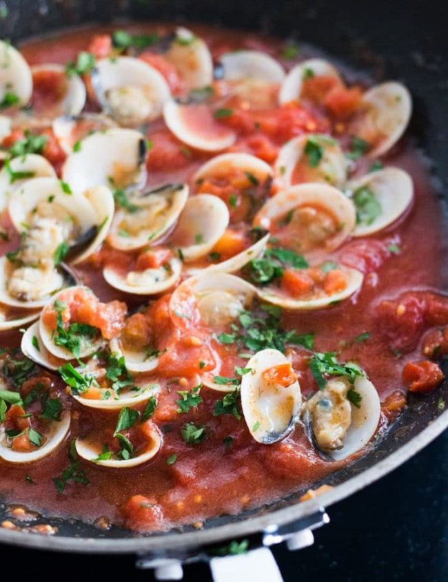 A close up of Red Clam Sauce in the pan with the clams open