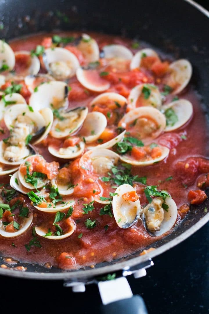 A close up of Red Clam Sauce in the pan with the clams open