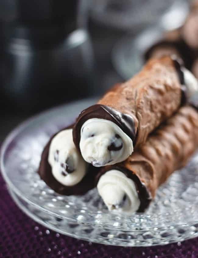 Homemade Cannoli filled and stacked on a crystal plate