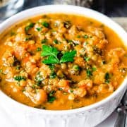 A bowl of lentil soup with fresh herb garnish