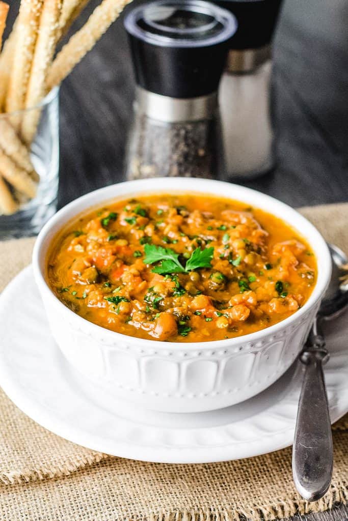 a big bowl of lentil soup garnished with parsley