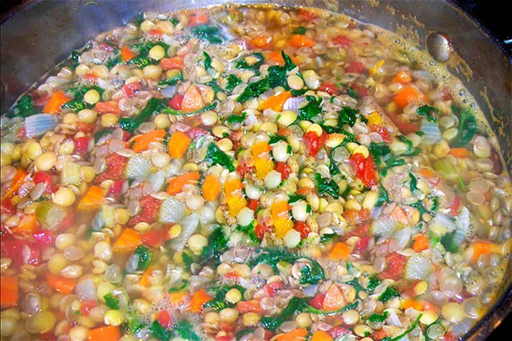 A close up of the lentils, stock, parsley, carrots, and onions before cooking down into the soupsley, carrots and onions before cooking down into the soup