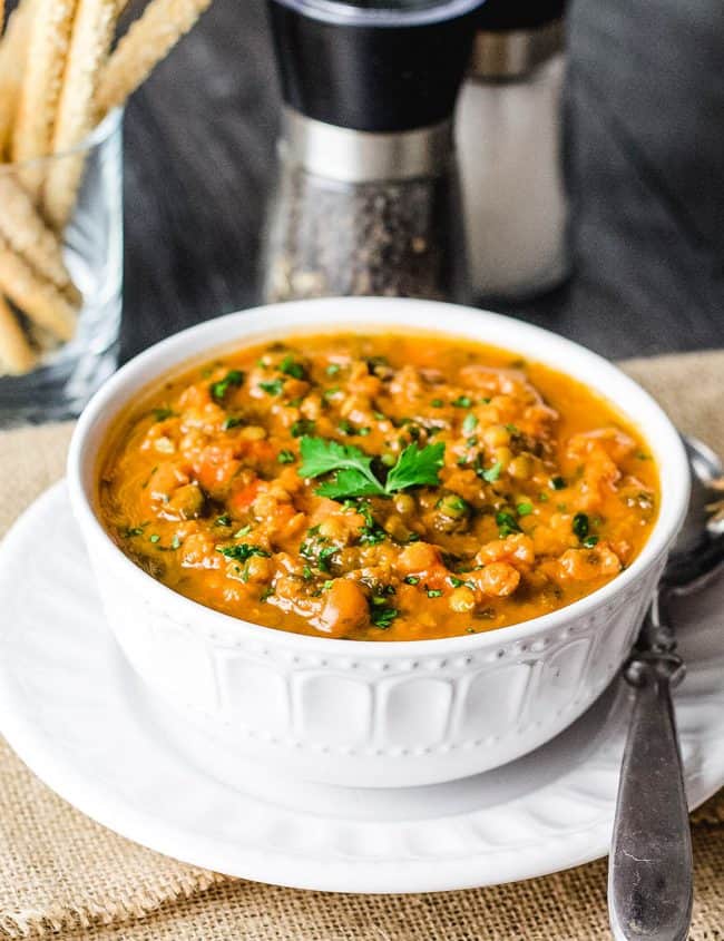 a big bowl of lentil soup garnished with parsley