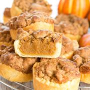 Pumpkin Streusel Tarts stacked on a cooling rack with one cut open to show the filling