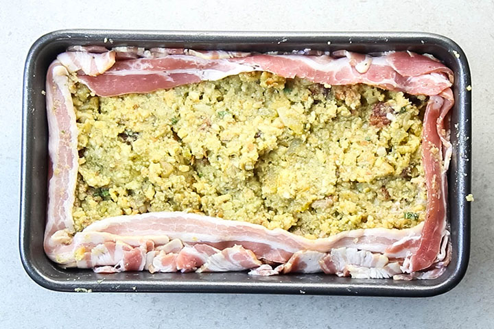 The bacon folded over the stuffing in the pan