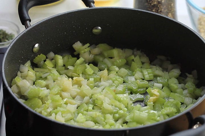 A pan with onions and celery cooking