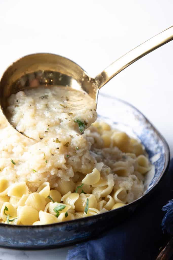 cauliflower sauce being ladled from a dish