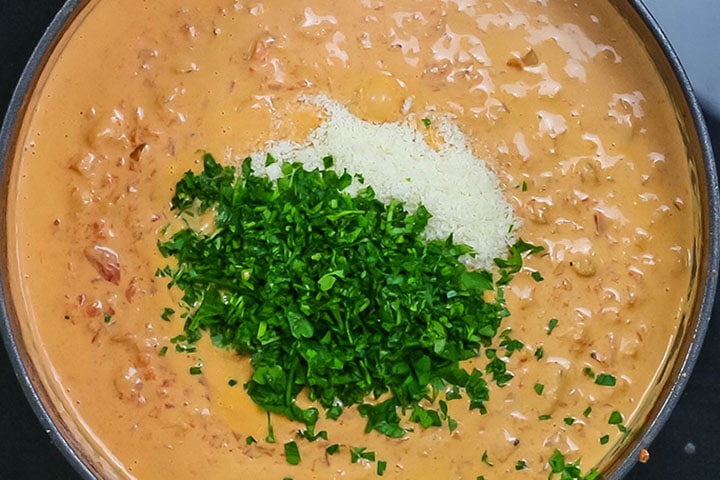 The cheese and parsley added to the sauce 