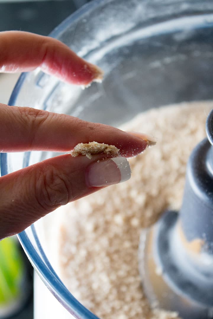 Two fingers pinching together the topping mixture