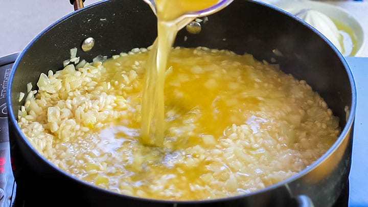 The stock added to the rice mixture in the pan