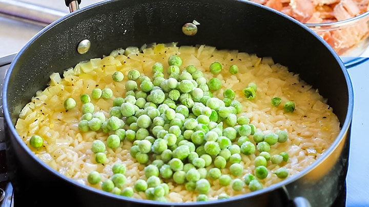 frozen peas added to the cooked rice in the pan