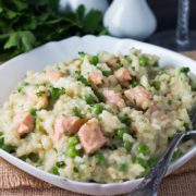 A dish of Easy Salmon and Pea Risotto with a fork laying in the dish next to it