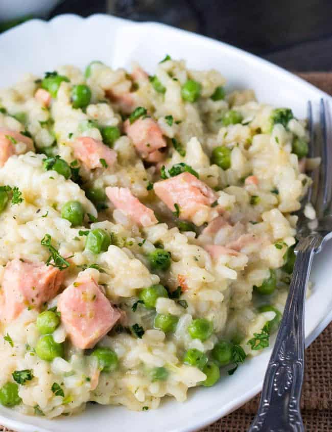 A dish of Easy Salmon and Pea Risotto with a fork laying in the dish next to it