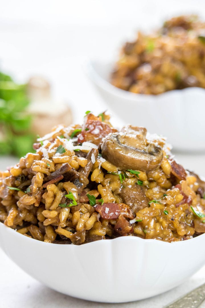 Two Bowls of Easy Mushroom & Bacon Risotto sprinkled with grated cheese and parsley